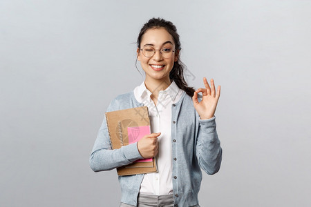 带着眼镜的女孩手上抱着笔记本图片