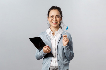 带着眼镜的女孩抱着文件夹手拿着笔图片