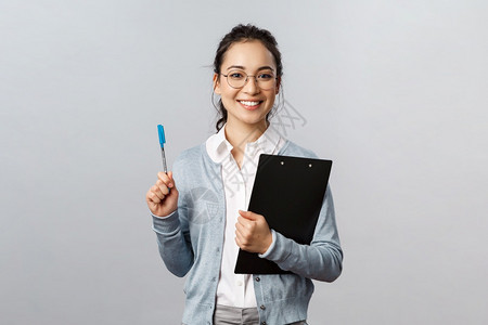 带着眼镜的女孩抱着文件夹手拿着笔图片