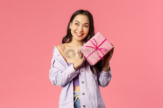 里面有什么好奇的可爱愚蠢亚洲女孩肖像拿着礼物摇盒子猜是什么笑着仰展示听好奇里面有什么拿着礼物摇盒子猜它是什么笑着图片