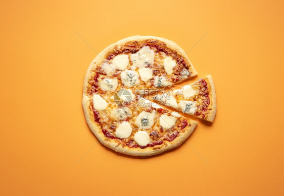 在橙色背景的典型平原披萨顶部视图中披萨里有一大堆的马铃薯帕梅桑和戈贡佐拉图片