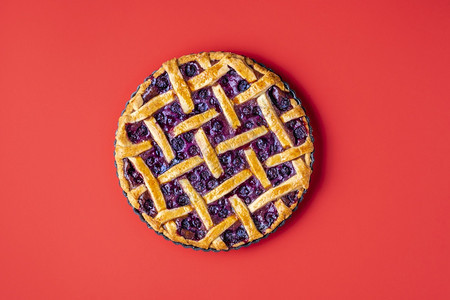 蓝莓馅饼夹着薄壳放在红色无缝背景的盘子上经典水果馅饼的顶层视图从头到尾的蓝莓薄饼name图片