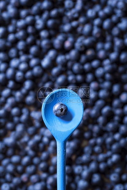 生蓝莓堆和汤匙仅含一个水果顶端是一只木勺上面是一只蓝莓水果准备吃夏季水果图片