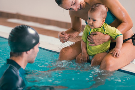 男婴和教练游泳班室内池图片