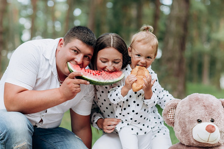 快乐家庭在野餐时吃西瓜的户外画像图片素材