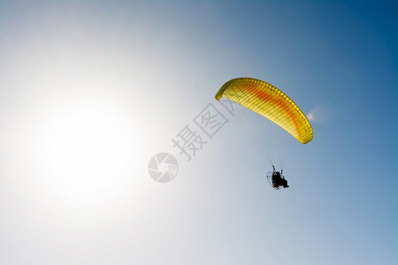 滑翔伞在蓝色天空上与抛光机一起飞行图片
