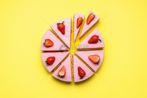 草莓芝士蛋糕切成不均匀的片段黄色无缝背景平躺着没有蛋糕的草莓果糖奶油甜点图片