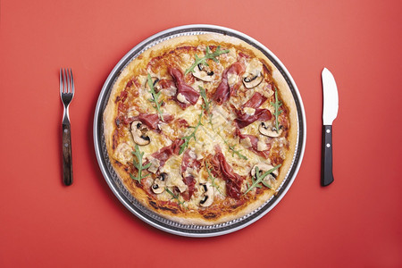 土制披萨配有香肠萝卜莫扎里拉和辣椒平躺着配火腿披萨准备吃辣椒和萝卜披萨的顶端风景图片
