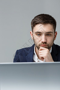 商业概念肖像英俊紧张的商人身着衣物冲击看笔记本电脑的工作白色背景在工作办公室的笔记本电脑前白色背景图片