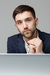 商业概念肖像英俊紧张的商人在工作办公室看着笔记本电脑白色背景图片