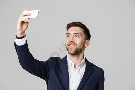 商业概念英俊的商人用智能手机自拍白色背景图片