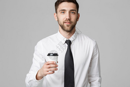 一位英俊商人的肖像穿着正式西装喝杯咖啡图片