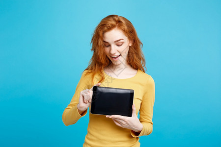 商业概念关闭肖像年轻美丽的有吸引力红头发女孩微笑着展示数字平板屏幕在黑色蓝的糊面背景图片