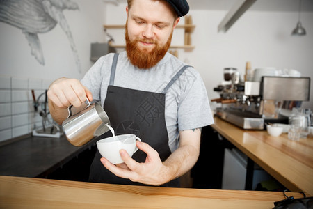 咖啡商业概念在咖啡馆站着时穿围裙咖啡的英俊长胡子男图片