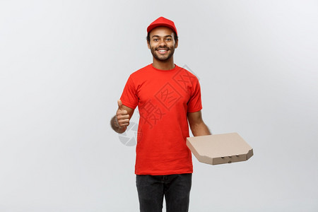 交付概念快乐的非洲送货员肖像他拿着一个披萨盒包并展示出震动孤立在灰色工作室背景上复制空间快乐的非洲送货员肖像显示震动复制空间图片