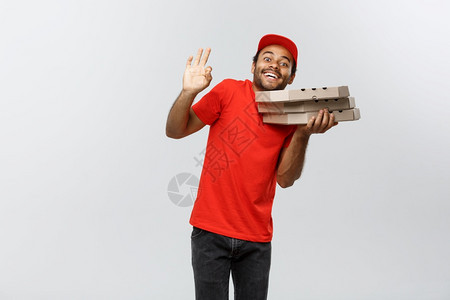 交付概念英俊的非洲比萨饼送货员用手指签好名的肖像孤立在灰色工作室背景上复制空间英俊的非洲比萨饼送货员的肖像孤立在灰色工作室背景上图片