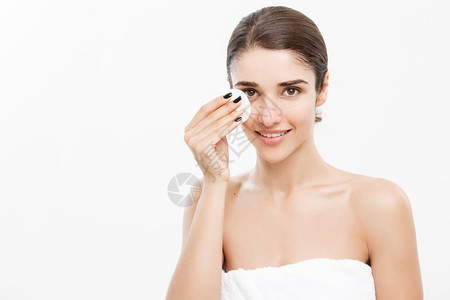 美容护肤概念美丽的妇女用棉布擦脸在白色背景和微笑下打扫脸部图片