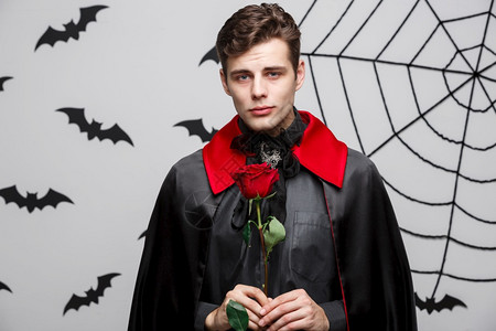 魔鬼表情包吸血鬼万圣节的概念英俊天主教吸血鬼肖像红色玫瑰背景