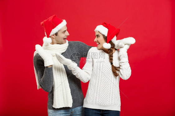 一对快乐的年轻夫妇肖像穿着红色工作室背景穿着红色工作室背景的年轻快乐夫妇肖像图片