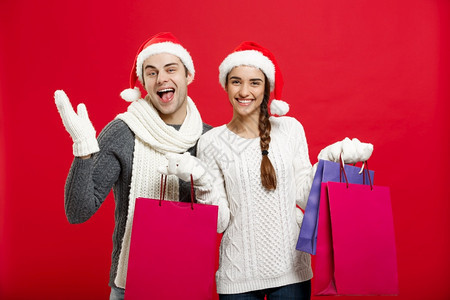 圣诞节概念持有购物袋的年轻吸引力夫妇享受购物和庆祝圣诞节持有购物袋的年轻吸引力夫妇享受购物和庆祝圣诞节图片