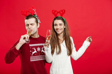 圣诞节概念穿着毛衣快乐的一对年轻夫妇庆祝圣诞节和香槟穿着毛衣快乐的一对年轻夫妇庆祝圣诞节和香槟图片