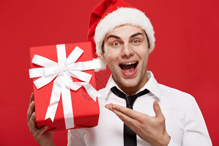 圣诞概念肖像近身圣誕商人在红色背景持有礼图片