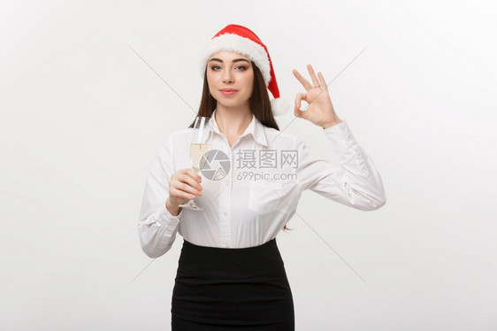 圣诞庆典年轻美丽的商业女人庆祝圣诞节喝着香槟展示好牌子图片