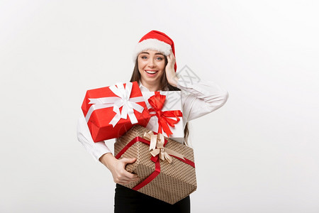 商业概念美丽的天主教青年女商人戴着圣塔帽拿许多圣诞礼物盒上面还有复制空间图片