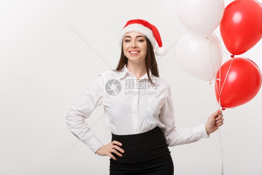 商业概念美丽的年轻自信女商人带着圣塔帽子拿气球庆祝圣诞节商业概念美丽的年轻自信女商人带着圣塔帽子拿气球庆祝圣诞节图片