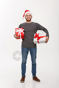 圣诞概念带着胡子的快乐年轻人带着许多礼物与白色背景隔绝图片