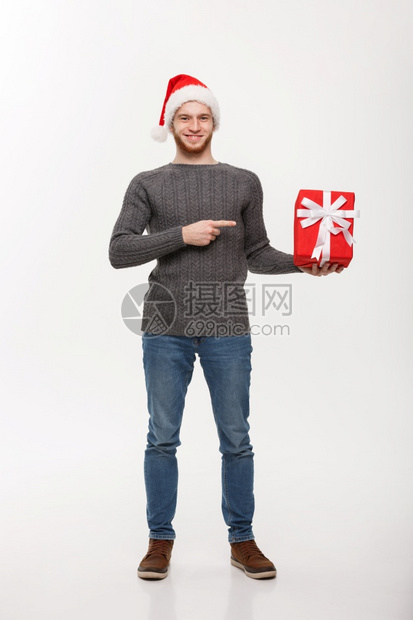 圣诞节概念快乐的年轻人胡子指着手与白种背景隔绝图片