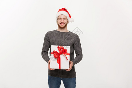 圣诞概念快乐的年轻英俊男子胡给摄影机送礼物图片