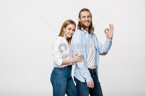 快乐的年轻夫妇做正确姿态孤立在白色背景上快乐的年轻夫妇做正确姿态孤立在白色背景上图片