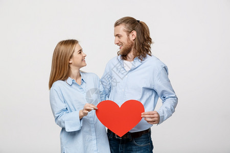 年轻快乐的情侣一起拿着一个大红心图片