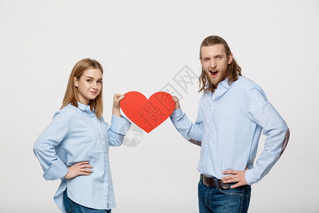 年轻快乐的情侣拿着一个大红心图片