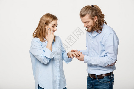 快乐的英俊男人肖像穿着订婚戒指为她的女朋友在孤立的白色背景上快乐的英俊男人肖像穿着订婚戒指为她的女朋友在孤立的白色背景上图片