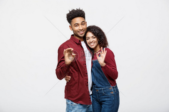 一对快乐的非洲年轻夫妇一起站在展示与白色背景隔离的好姿态一对快乐的非洲年轻夫妇一起站在展示与白色背景隔离的好姿态图片