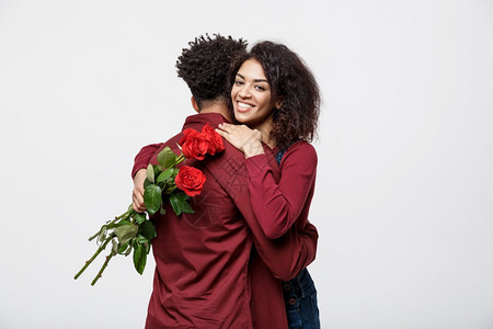 一对年轻的非洲夫妇拿着玫瑰花拥抱图片
