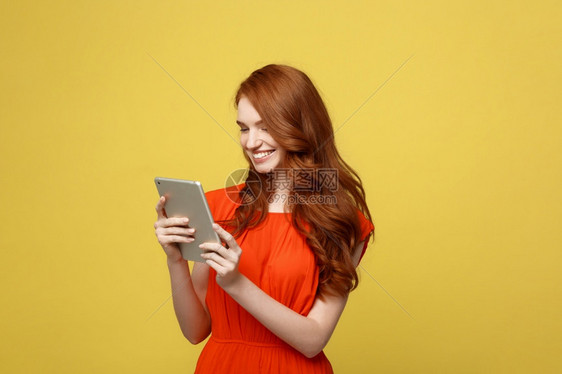 商业界妇女微笑的商人工作概念微笑的迷人红发女青年肖像她们工作用石板隔着明亮的黄色背景商业界妇女迷人的红发青年肖像她们工作用石板隔图片