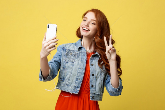 生活方式概念年轻快乐的女子在与朋友聊天时用智能手机照相拍摄自己吸引笑的时装女郎在手机上自画像生活方式概念年轻快乐的女子在与朋友聊图片