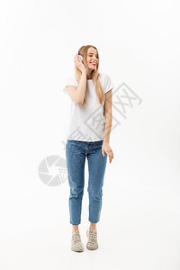 生活方式概念快乐的女学生用耳机听音乐的肖像却在孤立的白色背景下跳舞生活方式概念快乐的女学生用耳机听音乐的肖像在孤立白色背景下跳舞图片