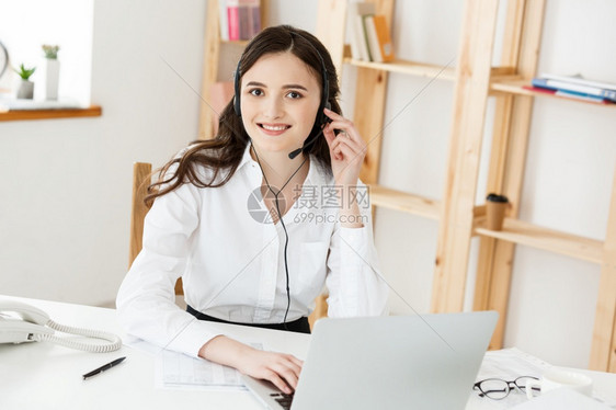 在呼叫中心工作的是青年友好经营人妇女代理或戴头盔的商业妇女在呼叫中心工作的是青年友好经营人妇女代理或戴头盔的商业妇女图片