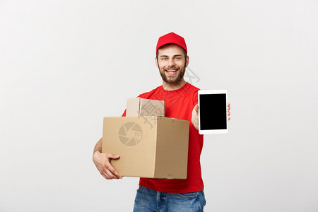 在线购物交付技术和生活方式概念微笑的送货人手持平板和箱子与白工作室背景隔绝与白工作室背景隔绝图片