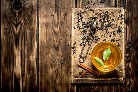 茶杯加绿色叶子木制背景图片