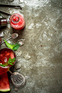 鸡尾酒西瓜片和薄荷冰块放在石头桌上的摇晃器中西瓜和薄荷图片