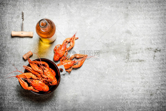煮的龙虾加一瓶白葡萄酒和柠檬片放在石头背景上煮的龙虾加一瓶白葡萄酒图片