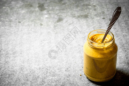 新鲜芥子酱放在罐里上加勺石头桌上新鲜芥子酱放在罐里图片