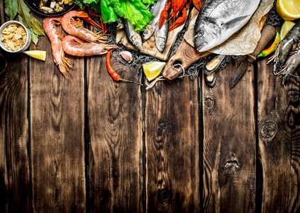 新鲜生海产食品渔网上的各种海产食品木质背景的海产食品渔网上的多种海产食品图片