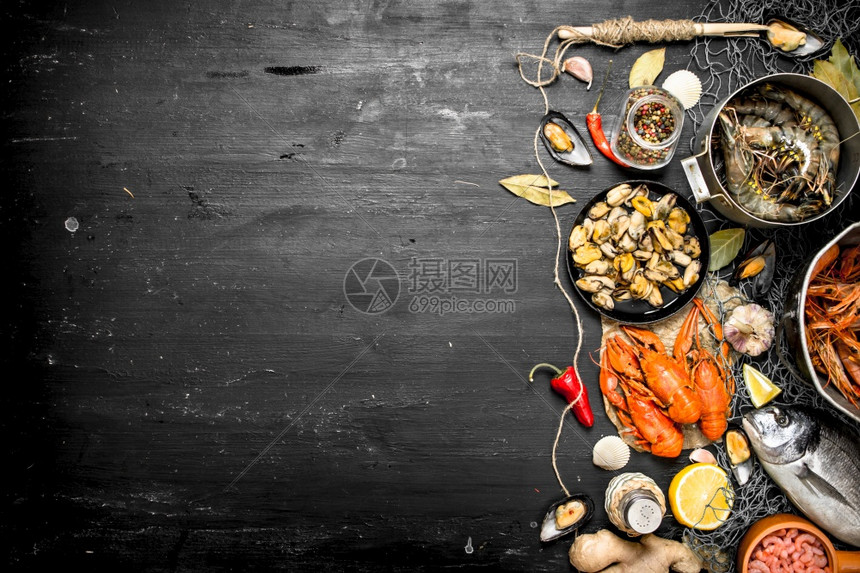 新鲜海产食品配有香料和草药的海产食品黑板上的海产食品配有香料和草药的海产食品图片