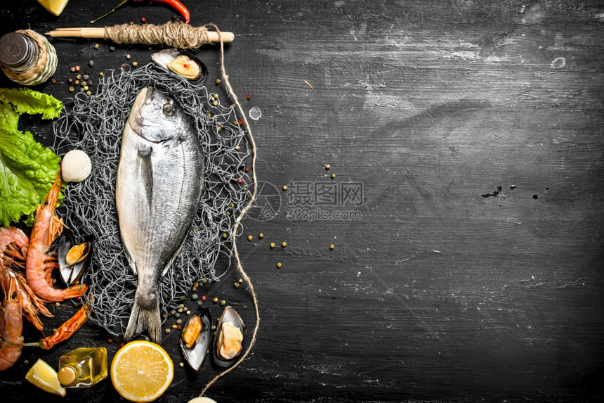 新鲜海鱼有虾柠檬和香料黑板上的新鲜鱼有虾柠檬和香料图片